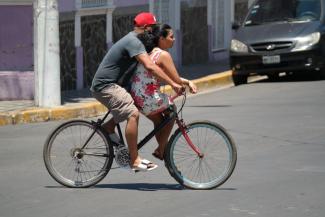 Mand cykler med sin kone